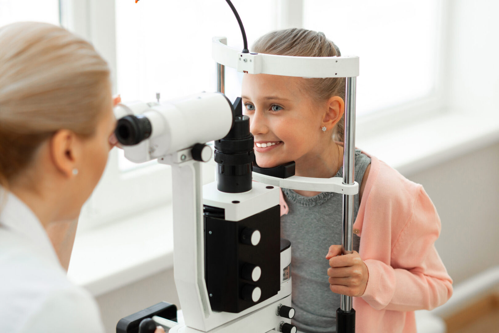 a girl taking an eye examination from doctor